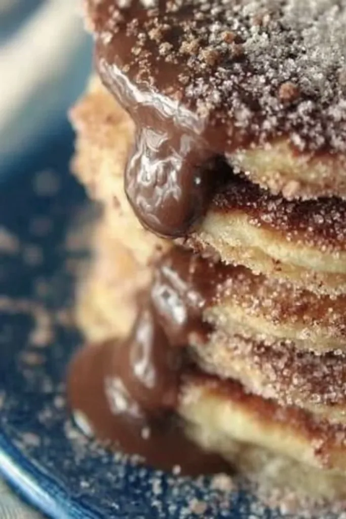 Delicious Churro Pancakes drizzled with syrup and sprinkled with cinnamon sugar