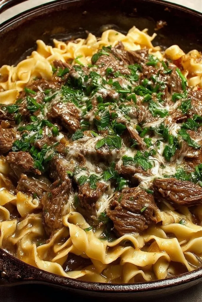 A bowl of beef noodles topped with fresh herbs and vegetables.
