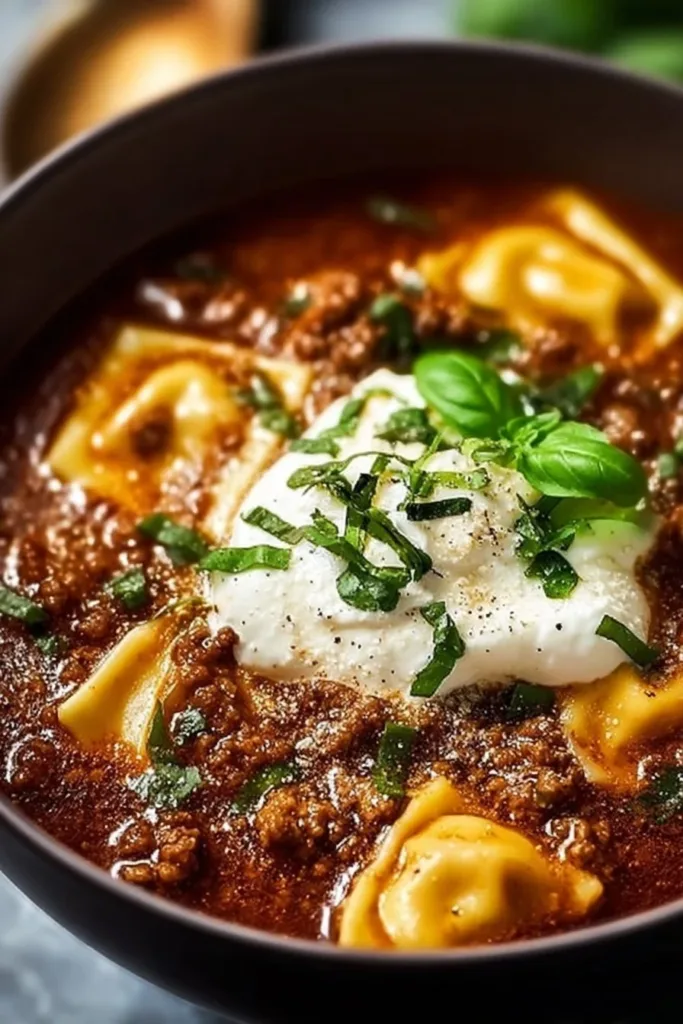 Bowl of delicious crockpot lasagna soup topped with cheese and herbs