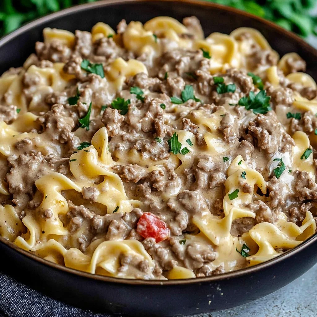 Delicious ground beef stroganoff served with egg noodles and garnished with parsley.